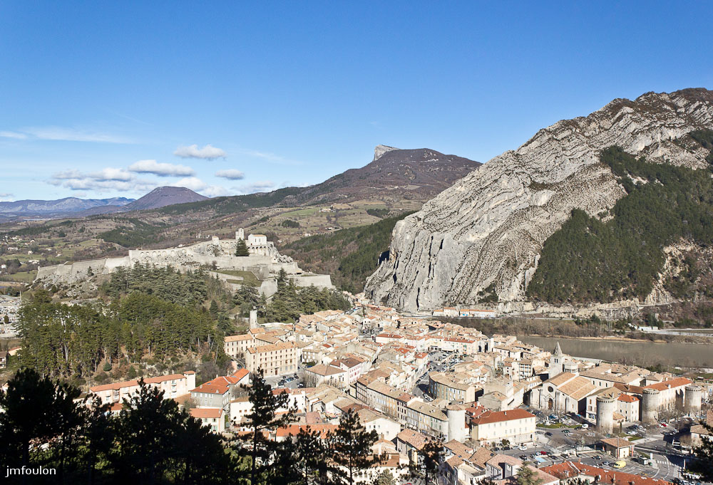 sist-zoom-001.jpg - La vieille ville, la citadelle et les Tours, vestiges des remparts qui la protégeaient jadis. Au loin de gauche à droite: La Crête des Selles (1380 m), Hongrie, Gache (1357 m) et la Baume (1147 m)