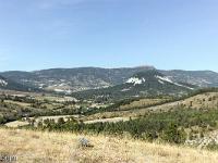 Séderon - La Tour  En face vers la droite avec ses flancs blancs, la montagne de Gonson (1101m). Au loin, les crêtes de la montagne de Chamousse qui culmine à 1532m ...